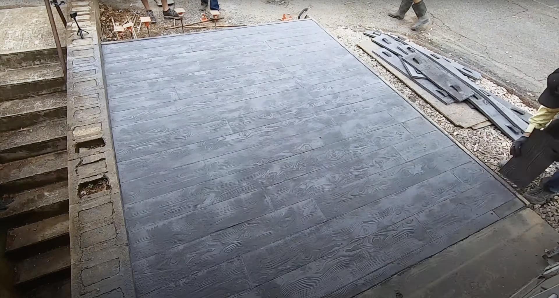 Stamped concrete patio installation with wood-grain pattern by Waterbury Concrete Construction Beautiful stamped concrete patio with wood-grain pattern showcasing decorative concrete work in Waterbury CT